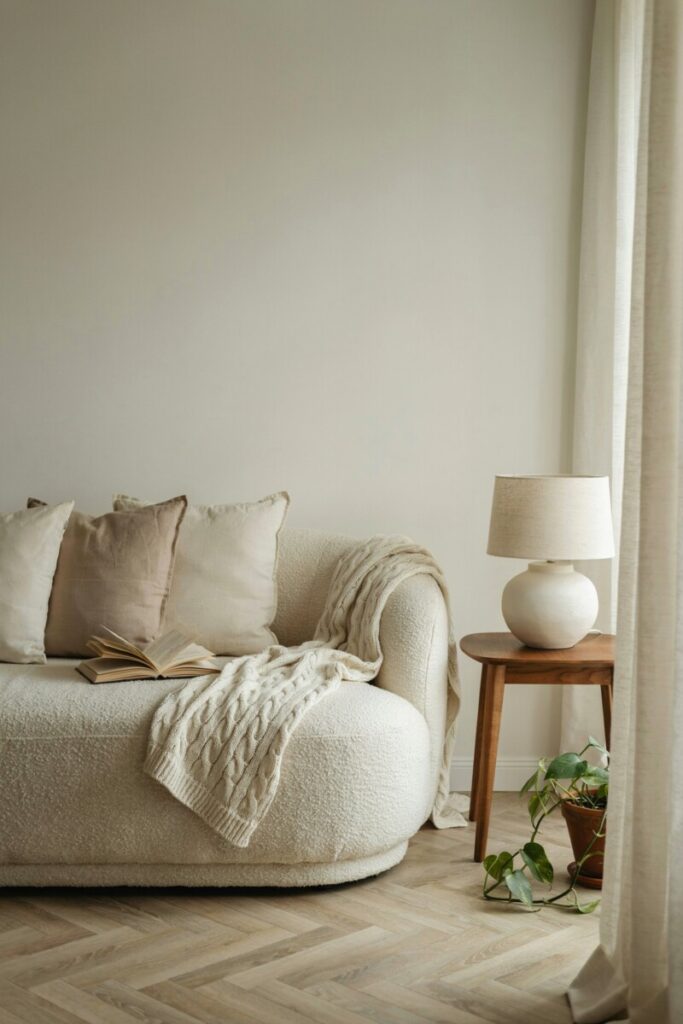 Cream bouclé sofa styled with linen pillows and knit throw in a warm minimalist living room