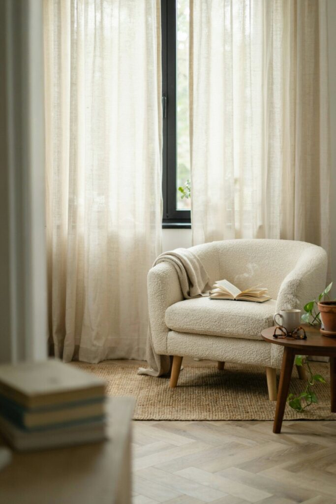 Ivory linen curtains filtering warm natural light in a calm, minimalist living space