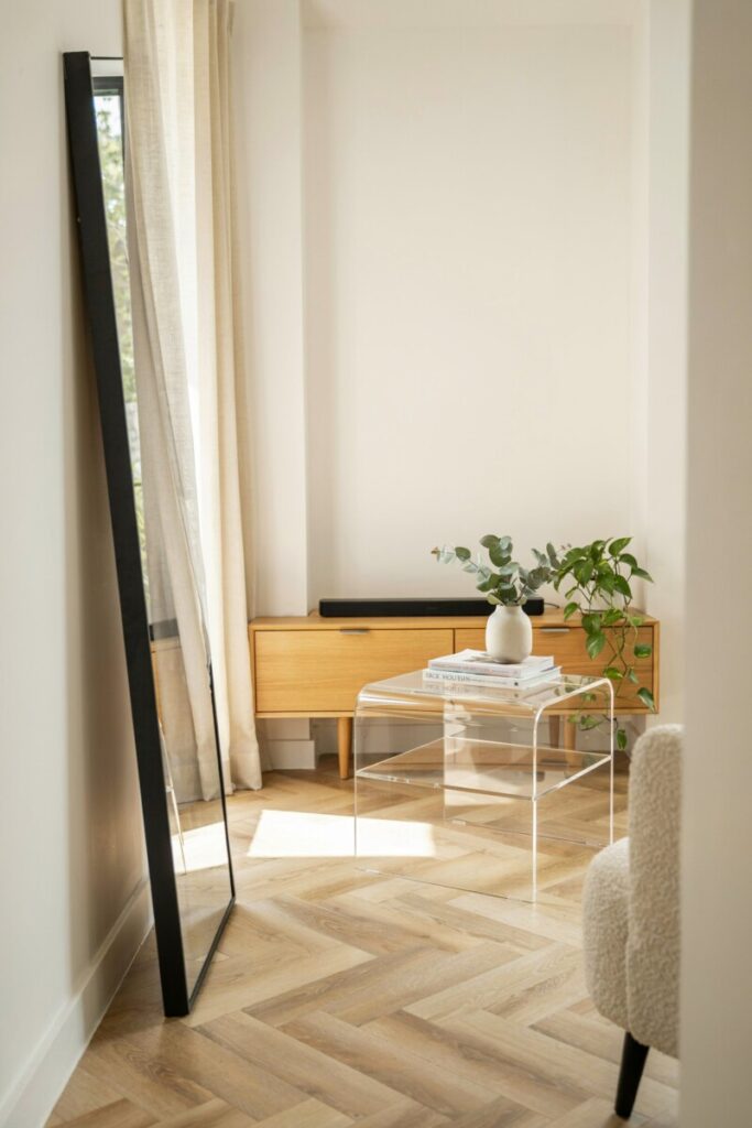 Space-saving furniture and narrow room decor ideas including a glass coffee table and large wall mirror.